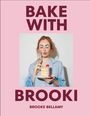 "BAKE WITH BROOKI" oben, "BROOKE BELLAMY" unten. Frau in blauem Hemd hält Kuchen mit Himbeeren, macht Lippenbewegung.