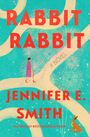 Text: "RABBIT RABBIT", "A NOVEL", "JENNIFER E. SMITH". Eine Frau spaziert auf einem Pfad, umgeben von Feuerwerkskörpern.