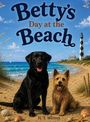 „Betty's Day at the Beach“ steht im oberen Bereich. Zwei Hunde sitzen am Strand, mit einem Leuchtturm und Meer im Hintergrund.