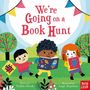 „We’re Going on a Book Hunt“. Drei Kinder lesen Bücher in einem bunten Park mit Dekoration und Bäumen.