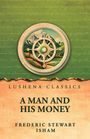 Text: "Lushena Classics. A Man and His Money. Frederic Stewart Isham." Illustration: Kompass vor Berglandschaft.