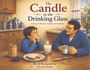 „The Candle in the Drinking Glass“, „A Story of Memory, Family, and Tradition“. Junge und Mann am Tisch mit Kerze.
