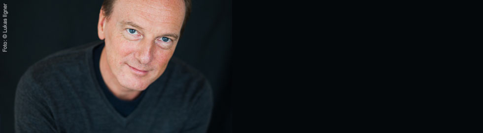 Marc Elsberg vor einem schwarzen Hintergrund